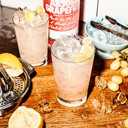 Two Grapefruit Coolers next to a bottle of Absolut Grapefruit vodka.