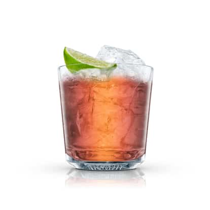 Grog in an Absolut rocks glass with ice and a lime wedge on white background