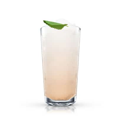 Indian Mule in a highball glass with crushed ice and a mint leaf on white background.