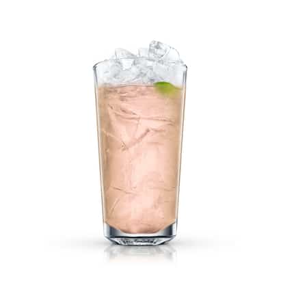 Island limeade served in a highball glass with crushed ice and a lime wedge on white background