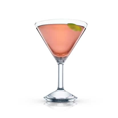 Pink cocktail in a martini glass garnished with a lime twist on white background.