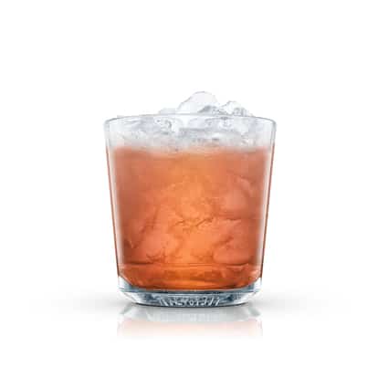 Red cocktail in an Absolut rocks glass with crushed ice on white background.