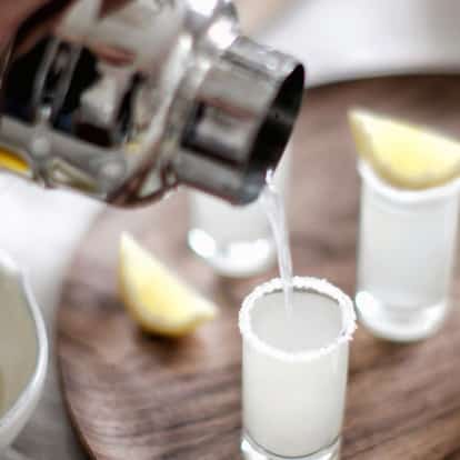 Lemon Drop Shots using Absolut Citron Vodka, garnished with a sugar-coated rim and lemon wedge