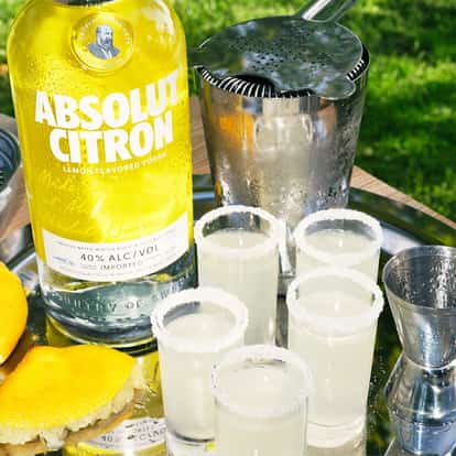 Lemon Drop Shots made with Absolut Citron Vodka, garnished with a sugar-coated rim and lemon wedge