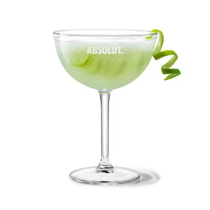 Limelet in an Absolut coupe glass garnished with a lime twist on white background.