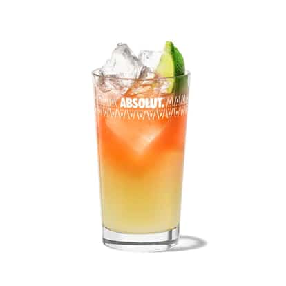 Malibu Bridgetown Breeze in an Absolut highball glass with ice and a lime wedge on white background