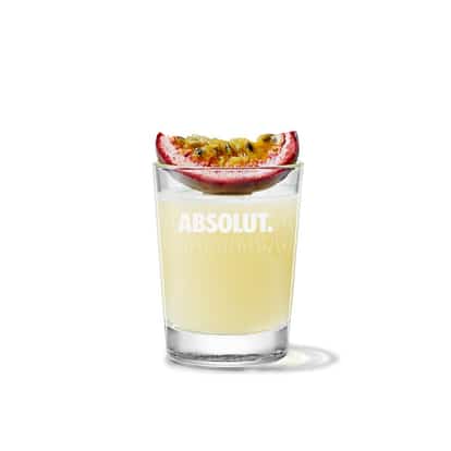 Mandrin & Passion Shot in an Absolut shot glass with a halved passionfruit on the rim