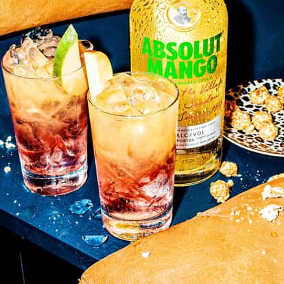 Two Mango Breeze cocktails next to a bottle of Absolut Mango.