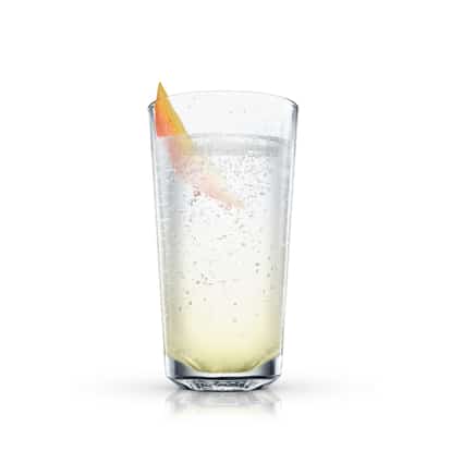 Pale yellow cocktail in a highball glass with a mango wedge on white background
