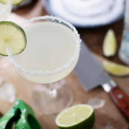 Margarita cocktail garnished with fresh lime and a salted rim.