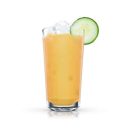 Creamy orange drink in a tall highball glass with ice and a cucumber slice on white background.