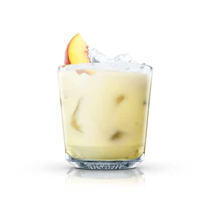 Peaches in an Absolut rocks glass with ice and a peach slice on white background