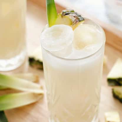 Pina Colada cocktails surrounded by fresh pineapple