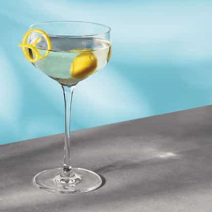 Point Blank in a coupe glass with lemon twist and lemon peel on tabletop