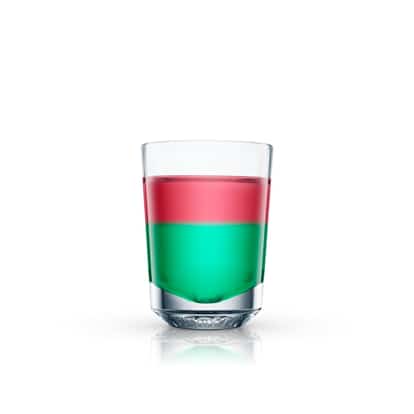 A layered red and green shooter in an Absolut shot glass on white background.