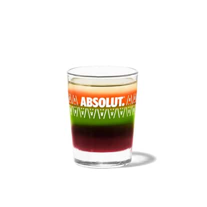 Pousse Café in an Absolut shot glass on white background.