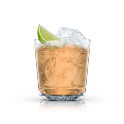Puerto Apple in an Absolut rocks glass with lime wedge and ice on white background