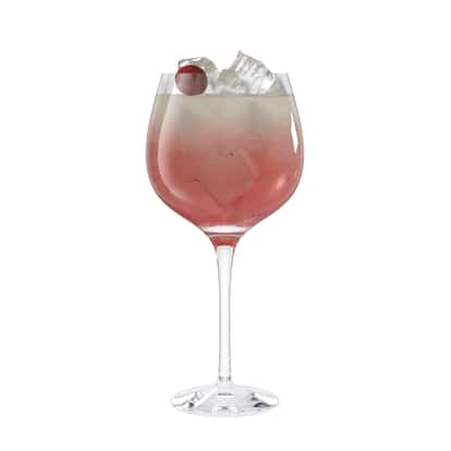 Reviver served in a stemmed wine glass with ice cubes and a cherry garnish on white background