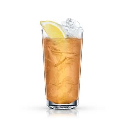 Rum Collins served in a highball glass with ice and a lemon wedge on white background