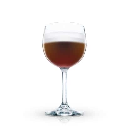 Schwarzwaldkaffe in a stemmed wine glass with a layer of froth on white background