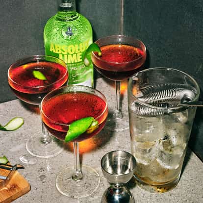 Sit Down cocktail next to a bottle of Absolut Lime vodka and a jigger.