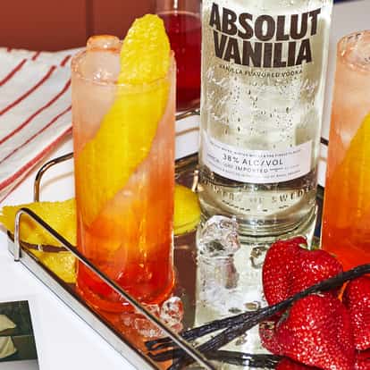 Strawberry and Cream Highball cocktail next to a bottle of Absolut Vanilia Vodka