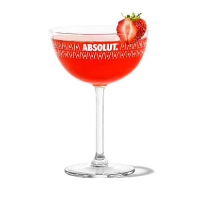 Strawberry Daiquiri in an Absolut coupe glass with a strawberry on the rim on white background
