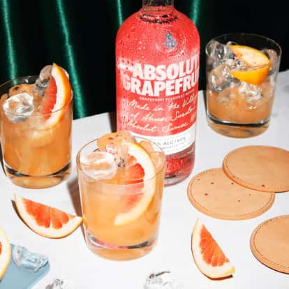 image with two orange cocktails and a bottle of Absolut Grapefruit