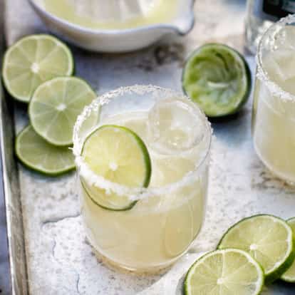 Tommy´s Margarita in a rocks glass with salted rim and lime wheel on a metal tray