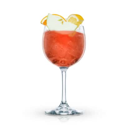 Virgin Sangria served in a wine glass with apple and citrus garnishes on white background.