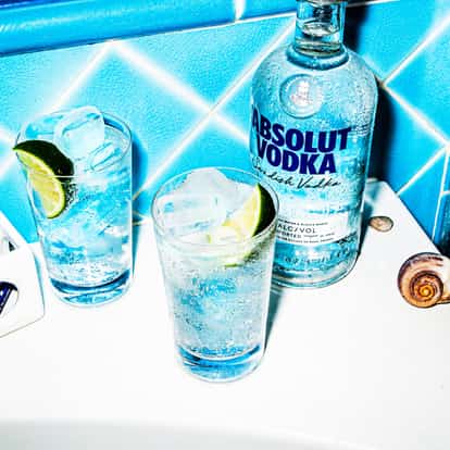 Classic Vodka Tonic beside a bottle of Absolut Vodka.