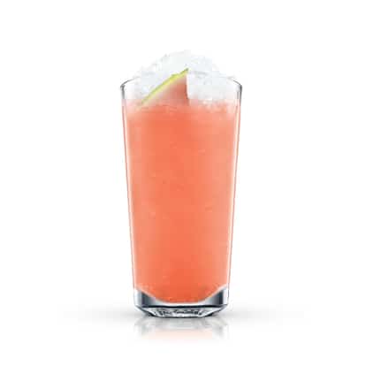 Watermelon Lemonade in a tall highball glass topped with crushed ice and a lime wedge on white background.