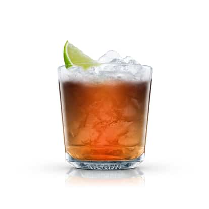 Whisky and Cola in an Absolut rocks glass with crushed ice and a lime wedge on white background