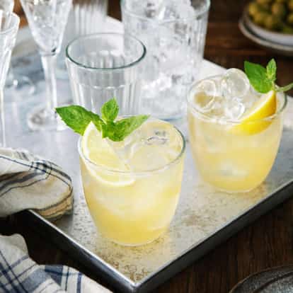Whiskey Smash cocktail garnished with lemon and mint leaves.