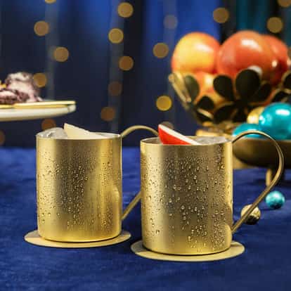 Yule, a Moscow Mule variation for the holidays, served in a traditional copper mule mug and garnished with a fresh apple slice.