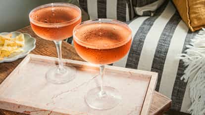 Cócteles Quattro Bianchi en copas coupé heladas, servidos en una bandeja de mármol rosado junto a snacks.