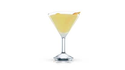 Apricot Mango Martini in a martini glass with a fruit wedge garnish on white background