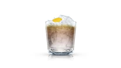 Black Magic in an Absolut rocks glass with crushed ice and lemon peel on white background