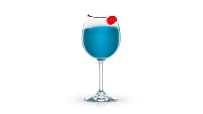 Blue Mediterranean in a wine glass with crushed ice and a maraschino cherry on white background