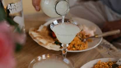 Bon Bon in a stemmed coupe glass poured from a small carafe with an Absolut bottle visible