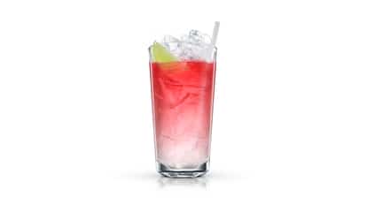 Butterfly Lemon in a highball glass with crushed ice, lime wedge and straw on white background