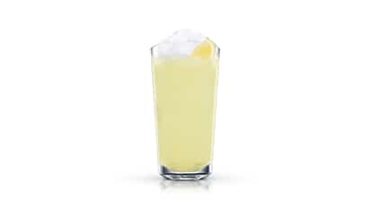 Citron Pressé in a highball glass with crushed ice and a lemon wedge on white background.