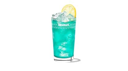 Cupids Blue is in an Absolut highball glass with ice and a lemon wheel on white background.