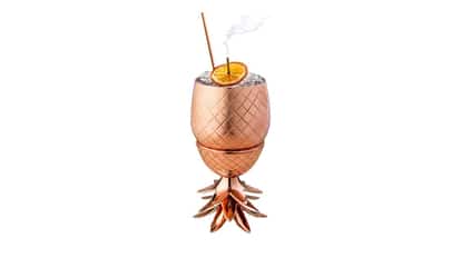 Orchard in a pineapple-shaped cup with crushed ice, an orange wheel and a straw