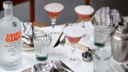 Es Saada served in coupe glasses with an Absolut Mandrin bottle and metal shaker on table