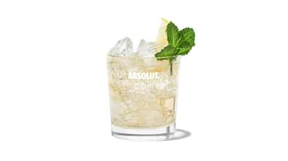 Ginger Queen Realness in an Absolut rocks glass with ice, lemon wedge and mint sprig on white background