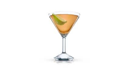 Ignorance Is Bliss in a martini glass with a lime wedge on white background