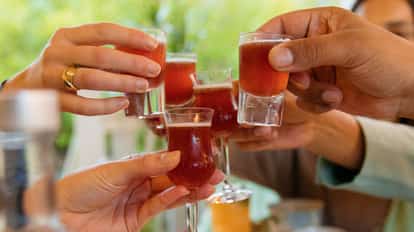 Illusion served in multiple shot and tulip glasses held aloft in a group toast