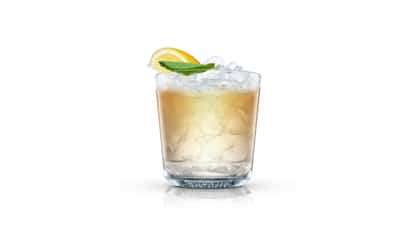 Just Add Ginger Ale in an Absolut rocks glass with crushed ice, lemon wedge and mint leaf on white background