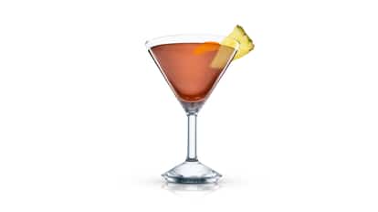 King’s Club in a martini glass with a pineapple wedge on white background